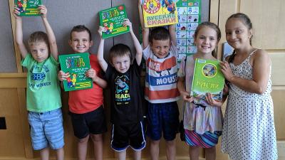 Six kids holding up their books.
