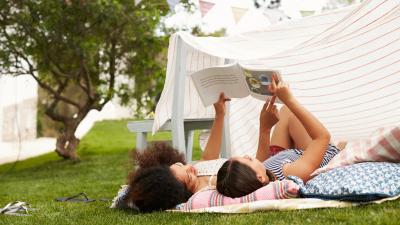family laying outside reading in a fort