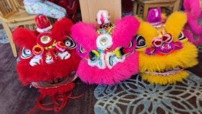  three ornate lion dance costume heads sit in a row