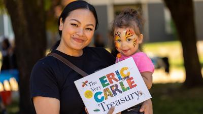 Woman and toddler holding an Eric Carle book