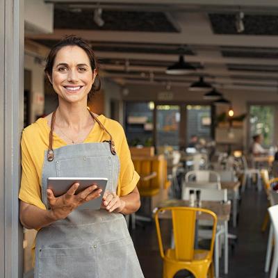 Person wearing an apron n a restaurant holding a device