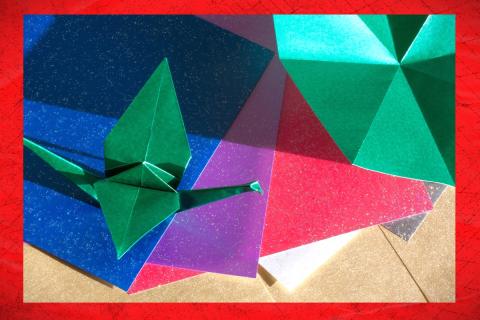 origami papers scattered beneath folded origami shapes