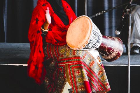 a Somali woman with drum sitting at a microphone