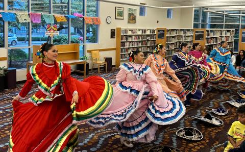 photo of dancers in traditional folklorico dresses performing
