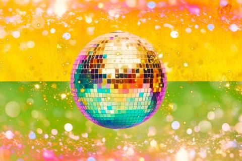 a disco ball floating on a yellow and green background with glitter