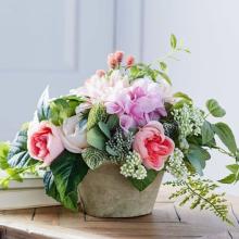 a photograph of an arrangement of pink flowers and greenery