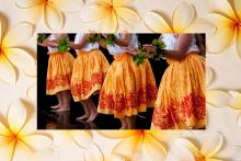 photograph of hula dancers in orange skirts, orange plumerias flowers in the background