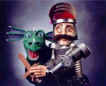 Image of a green dragon puppet and a mustachioed knight puppet