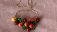 Colorful clay modeled to look like apples and leaves forming a necklace