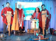 photo of four musicians on stage with traditional instruments and attire