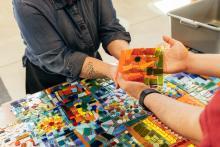 Hands with colorful tiles for mosaic