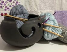 Two skeins of yarn and a black bowl