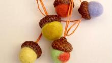 Photo of several felted acorns on string