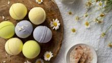 photo of bath bombs with herbs and flowers scattered around