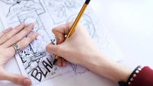 Photo of a person drawing a comic with a pencil