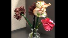 Photo of ribbon flowers in different colors sitting in a glass vase