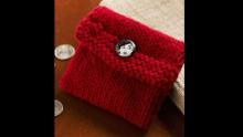 Photo of a red knitted coin purse with a button.