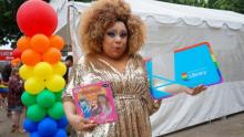 Photo of LadyBerri with pride library card and book