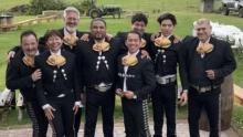 group of Mariachi dressed in black on a green lawn