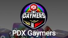 Photo of the PDX Gaymers logo with rainbow dice behind it.