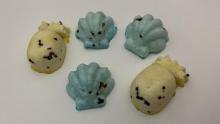 array of seed balls in green and yellow, shaped like shells and amimals