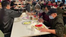 Photo of people gathering at a Vietnamese event, crafting at a table