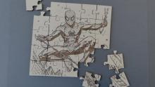 A photo of a small wooden puzzle engraved and cut with a laser cutter.