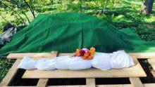 photo of a shrouded body on a plywood treste