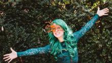 photo of Jess Campbell in green hair and mask, looking like a forest sprite