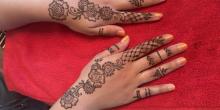 Photo of a teen's hand with floral henna art