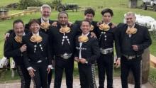 group of Mariachi dressed in black on a green lawn