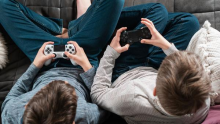 Photo of two teens playing video games