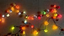 Photo of strands of origami lights in different colors pinned to a wall