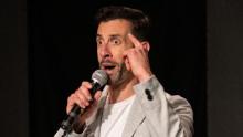 Photo of Stefano Iaboni performing comedy while holding a microphone
