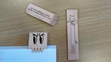 A photo of three laser-engraved leather bookmarks in different designs