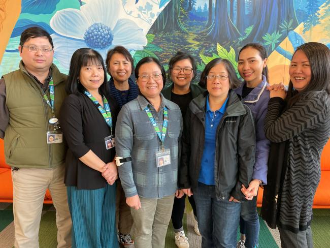 Đội ngũ nhân viên nói tiếng Việt của thư viện đứng cùng nhau và nở nụ cười trên môi