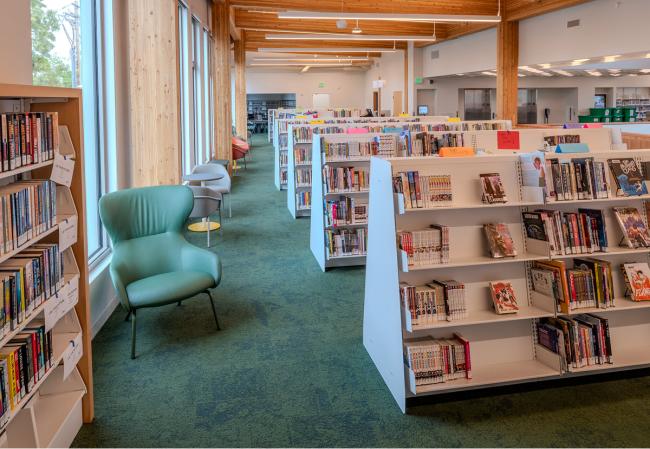 Inside Holgate Library, in a large room filled with bookshelves, and seating by the windows